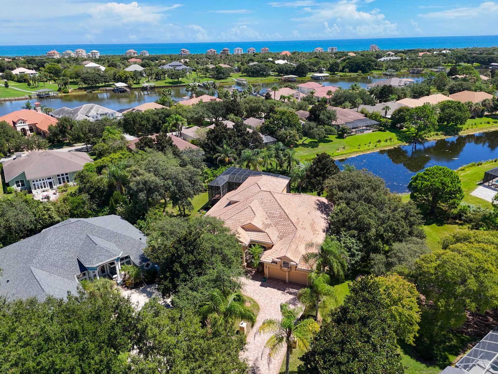 Aerial view of 18 N Park Lane showing the tile-roof pool home, private cul-de-sac drive, Intracoastal lakes, and the Atlantic Ocean beyond